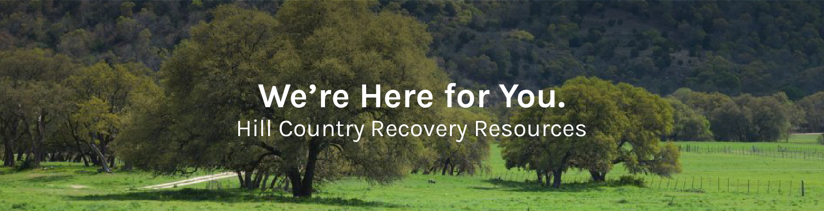HillCountryResourcesRelief_Mobile Scenic landscape of the Texas Hill Country featuring large oak trees and rolling green fields, with the text “We’re Here for You. Hill Country Recovery Resources” centered in white.